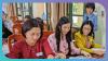 Three people work together on documents. ​