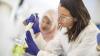 Two young women experiment in a lab with liquid